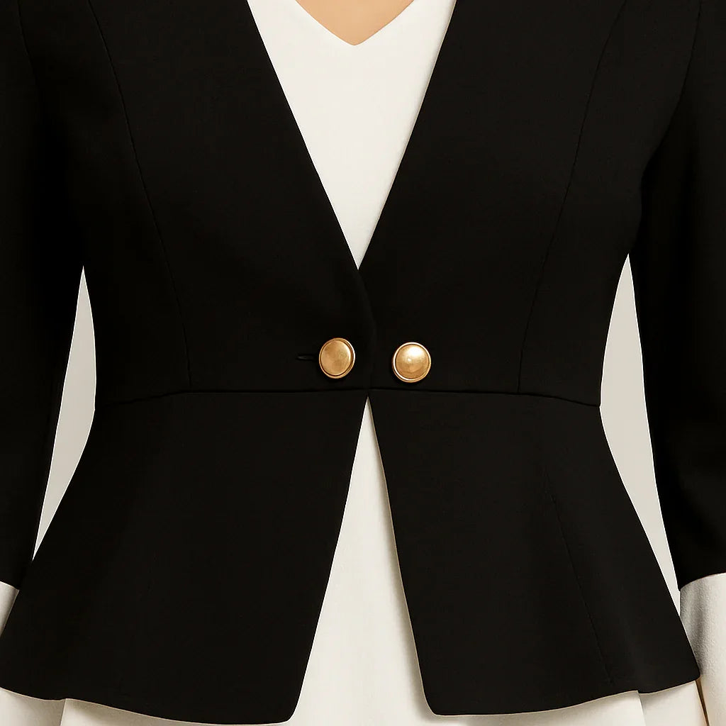 Svart kavaj med guldknappar, lager på lager i vit kant och utsvängda manschetter