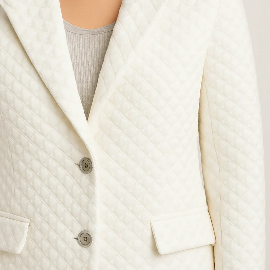 Vit texturerad kavaj med quiltat tyg och två knappar fram
